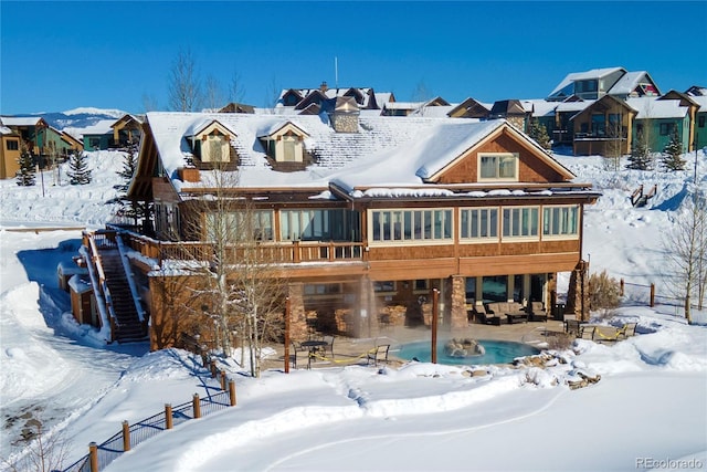 snow covered rear of property with a residential view