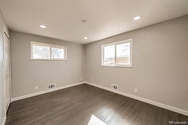 interior space with multiple windows, dark wood finished floors, and visible vents