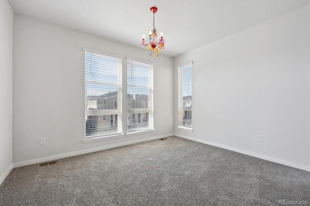 empty room featuring visible vents, carpet floors, a notable chandelier, and baseboards