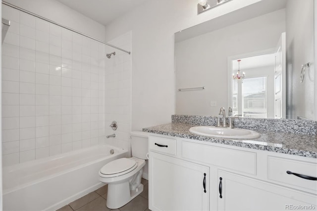 bathroom featuring tile patterned flooring, toilet, vanity, and shower / washtub combination