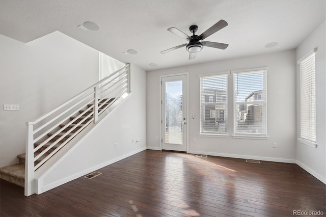 unfurnished living room with visible vents, stairs, baseboards, and wood-type flooring