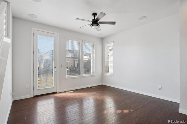 unfurnished room with visible vents, a ceiling fan, baseboards, and hardwood / wood-style floors