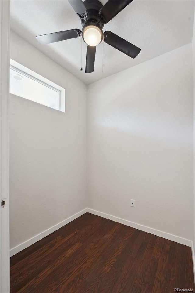 spare room with ceiling fan, baseboards, and dark wood finished floors