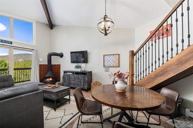 2449 Ryan Gulch Ct Unit 2449, Silverthorne, CO 80498 - dining space with light wood-style flooring, a wood stove, stairway, baseboard heating, and beam ceiling