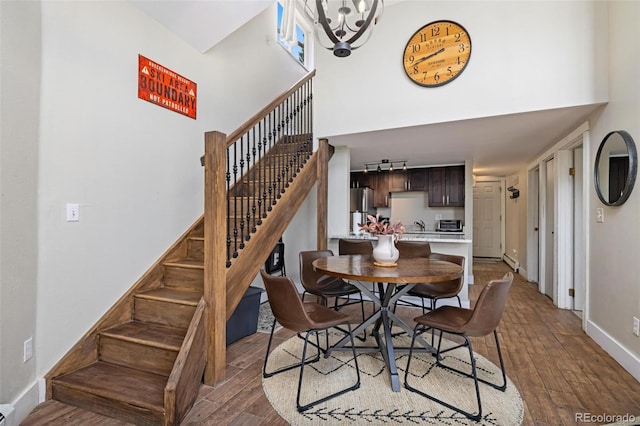 2449 Ryan Gulch Ct Unit 2449, Silverthorne, CO 80498 - dining area featuring a high ceiling, stairs, hardwood / wood-style floors, and a chandelier