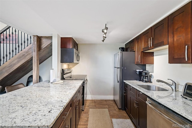 2449 Ryan Gulch Ct Unit 2449, Silverthorne, CO 80498 - kitchen with stainless steel appliances, light wood-style flooring, light stone counters, and a peninsula