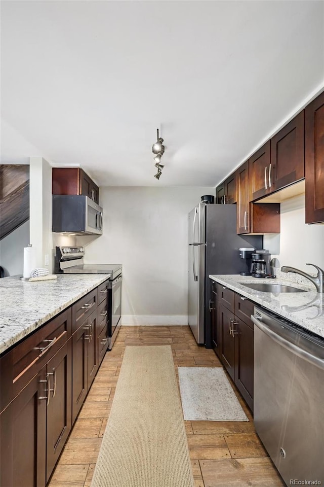 2449 Ryan Gulch Ct Unit 2449, Silverthorne, CO 80498 - kitchen featuring appliances with stainless steel finishes, light wood-type flooring, light stone counters, and dark brown cabinetry