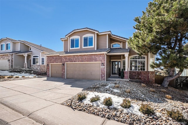 view of front of house with a garage, concrete driveway, brick siding, and fence