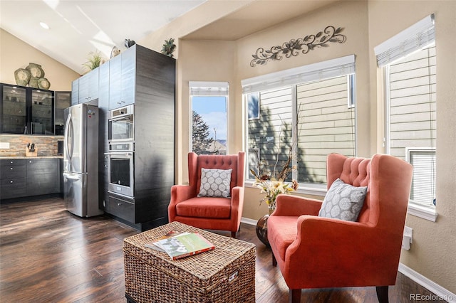 living area featuring vaulted ceiling, baseboards, and dark wood finished floors