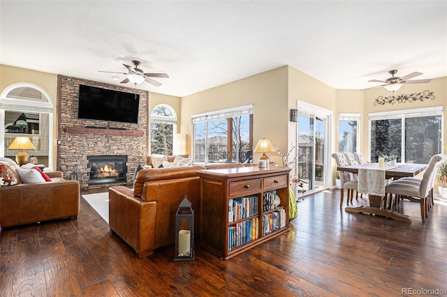 living area with a ceiling fan, a fireplace, and hardwood / wood-style floors