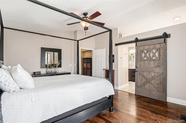 bedroom with lofted ceiling, a barn door, wood-type flooring, and baseboards