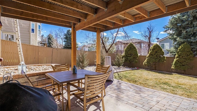 view of patio with outdoor dining space, a fenced backyard, and grilling area