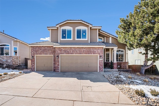 view of front of property with a garage, concrete driveway, brick siding, and a tiled roof