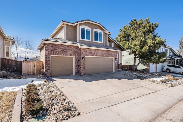 view of front of house featuring an attached garage, fence, concrete driveway, and brick siding