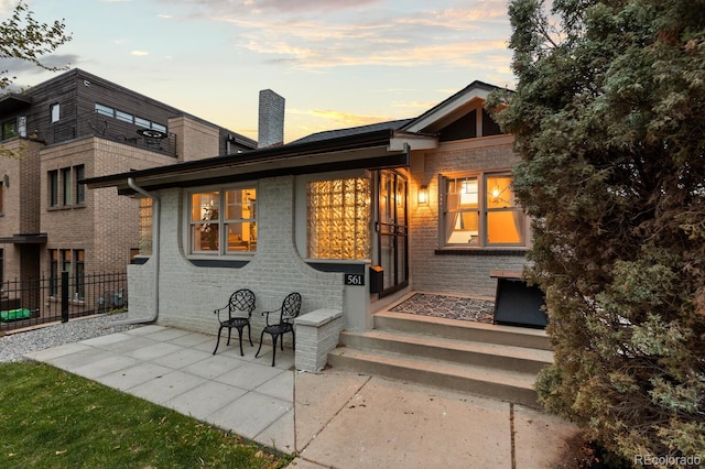 561 Cook St, Denver, CO 80206 - back of property with fence, a chimney, brick siding, and entry steps