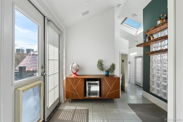 561 Cook St, Denver, CO 80206 - entryway featuring wine cooler, healthy amount of natural light, high vaulted ceiling, a skylight, and light tile patterned flooring