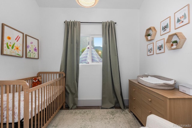561 Cook St, Denver, CO 80206 - bedroom with a nursery area and light wood-style flooring