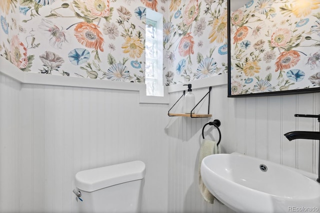 561 Cook St, Denver, CO 80206 - half bathroom with a sink, toilet, and a decorative wall