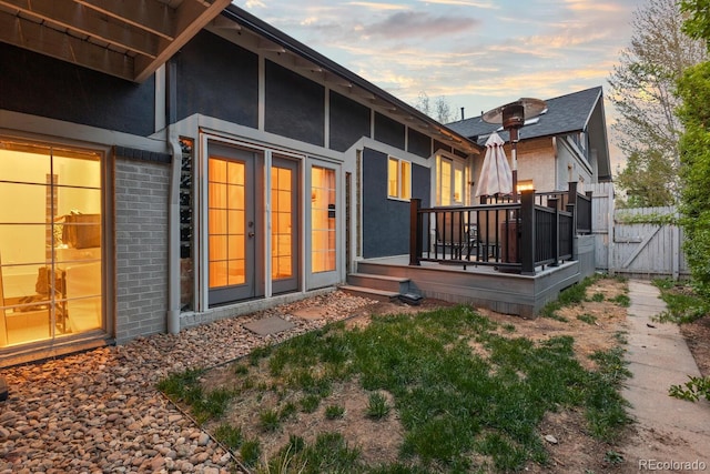 561 Cook St, Denver, CO 80206 - rear view of house with a wooden deck, brick siding, a gate, stucco siding, and fence