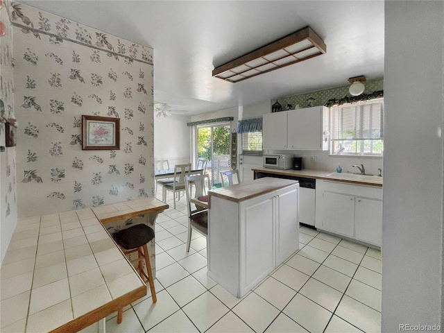 6236 Ingalls Ct, Arvada, CO 80003 - kitchen featuring white appliances, tile counters, white cabinets, healthy amount of natural light, and wallpapered walls