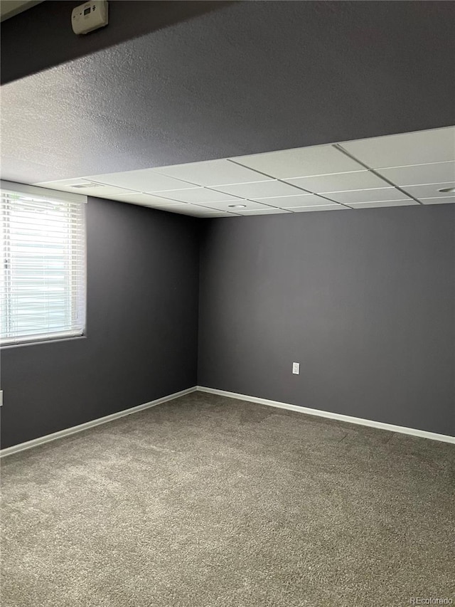 carpeted spare room featuring a paneled ceiling