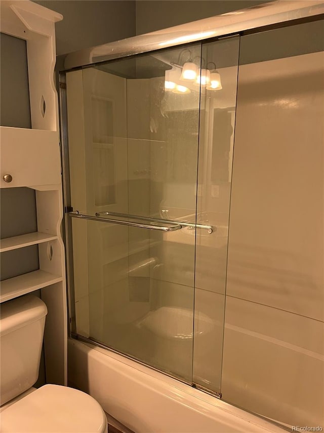 bathroom with enclosed tub / shower combo and toilet