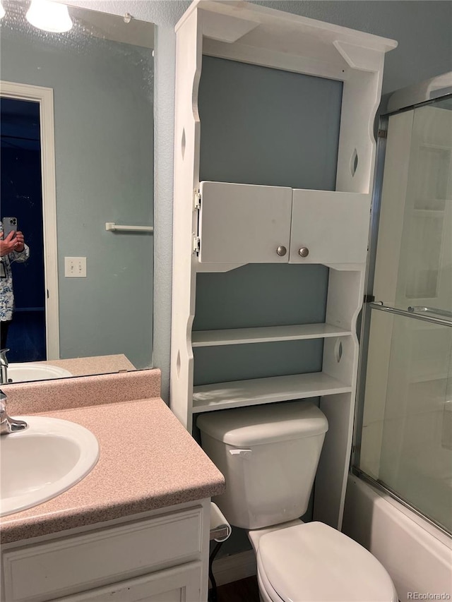 full bathroom with shower / bath combination with glass door, a textured ceiling, toilet, and vanity