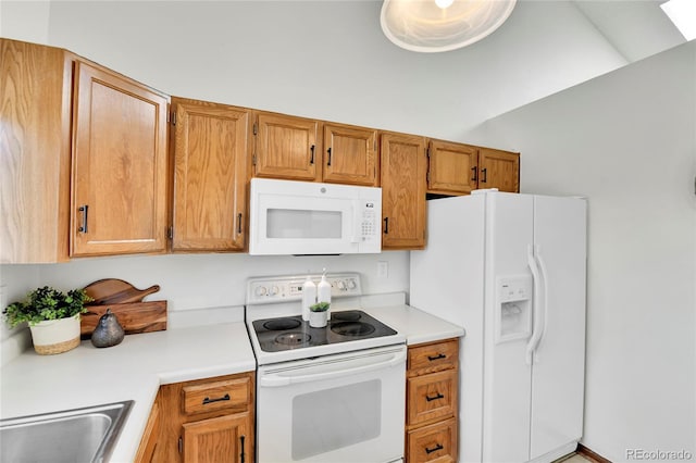 kitchen featuring light countertops, brown cabinets, white appliances, and a sink