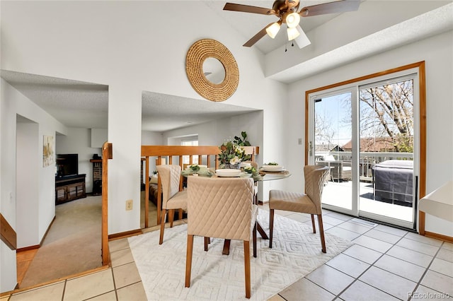dining room featuring baseboards, a ceiling fan, light tile patterned floors, and vaulted ceiling