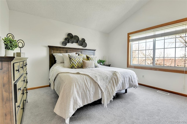 bedroom with a textured ceiling, visible vents, vaulted ceiling, baseboards, and carpet