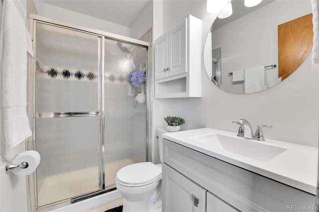 bathroom with vanity, toilet, and a shower stall