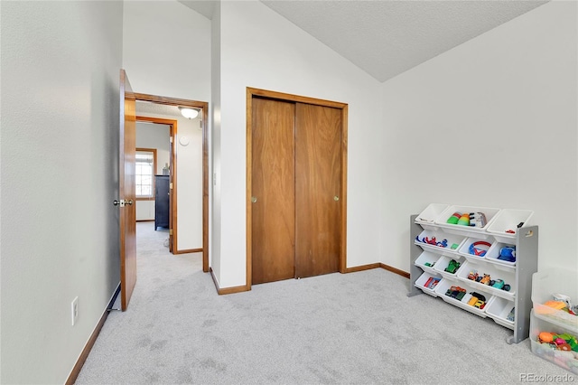 recreation room with baseboards, carpet, and vaulted ceiling