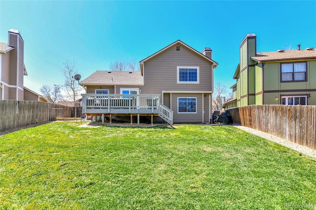 rear view of property with a lawn, a deck, stairway, and a fenced backyard