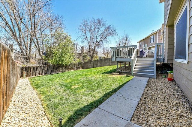 view of yard with a fenced backyard, a deck, and stairway