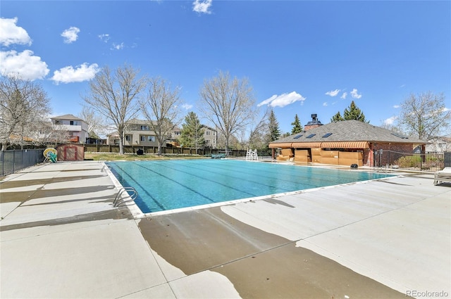 community pool with fence and a patio