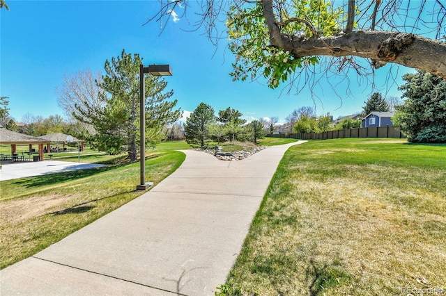 view of community featuring a yard and fence