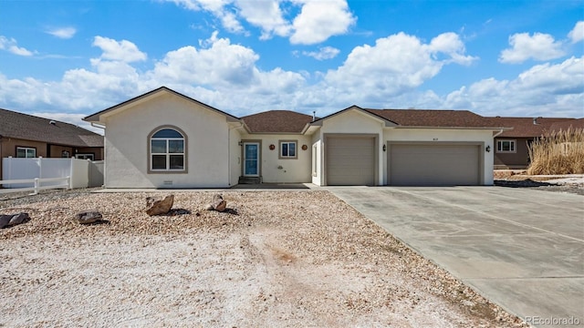 single story home with driveway, an attached garage, fence, and stucco siding