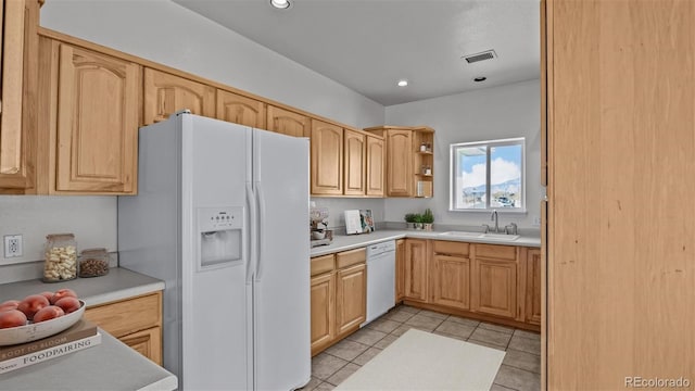 kitchen featuring light tile patterned floors, white appliances, a sink, visible vents, and light countertops