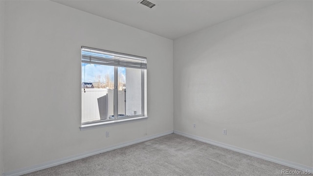 spare room featuring carpet floors, baseboards, and visible vents