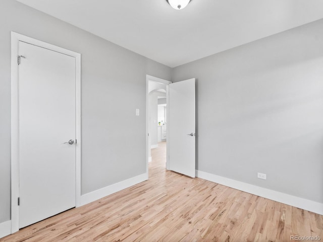 3630 Magnolia St, Denver, CO 80207 - unfurnished bedroom with wood finished floors, baseboards, and arched walkways
