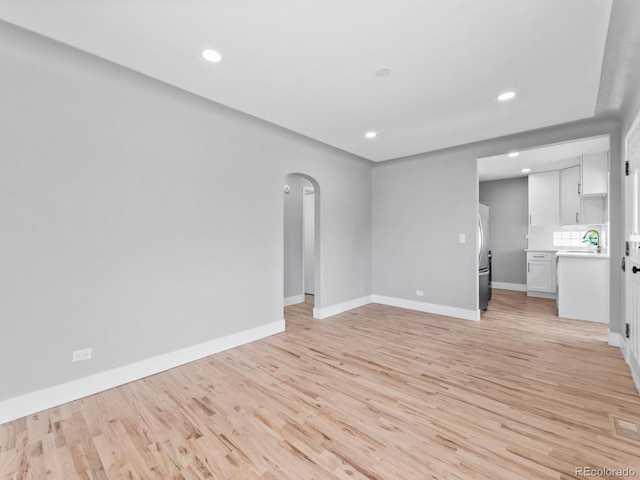 3630 Magnolia St, Denver, CO 80207 - unfurnished living room with light wood-style floors, arched walkways, baseboards, and recessed lighting
