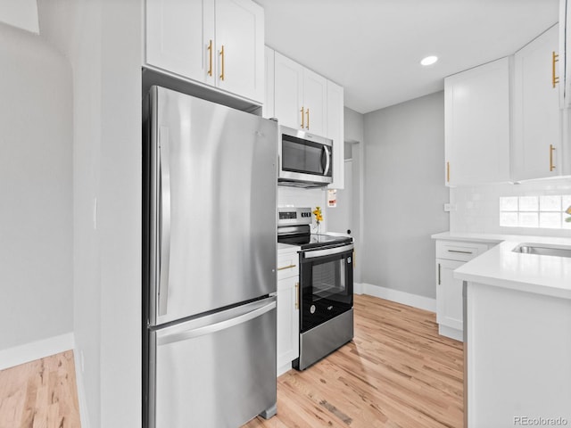 3630 Magnolia St, Denver, CO 80207 - kitchen with stainless steel appliances, white cabinetry, backsplash, light wood-style floors, and recessed lighting