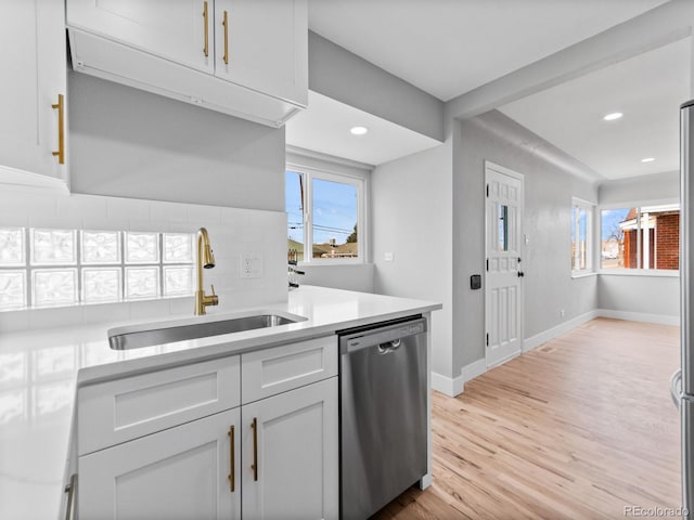3630 Magnolia St, Denver, CO 80207 - kitchen with stainless steel dishwasher, a sink, tasteful backsplash, light countertops, and light wood-style flooring