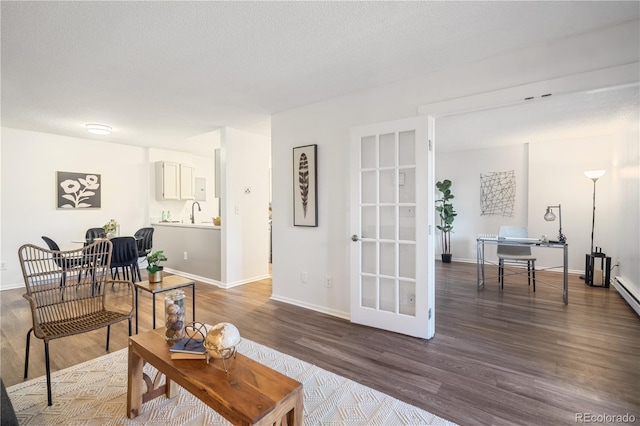 14751 E Tennessee Dr Unit 228, Aurora, CO 80012 - living area featuring wood finished floors, a desk, baseboards, and a textured ceiling