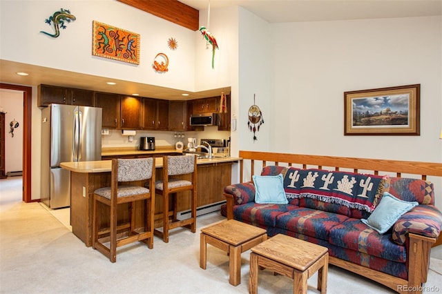 324 W Main St, Frisco, CO 80443 - living area featuring baseboard heating, light colored carpet, a towering ceiling, a baseboard radiator, and beam ceiling