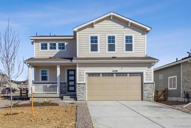 craftsman-style house with stone siding, covered porch, driveway, and a garage