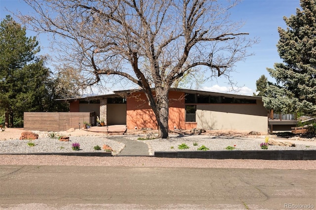 mid-century inspired home with stucco siding and an attached garage