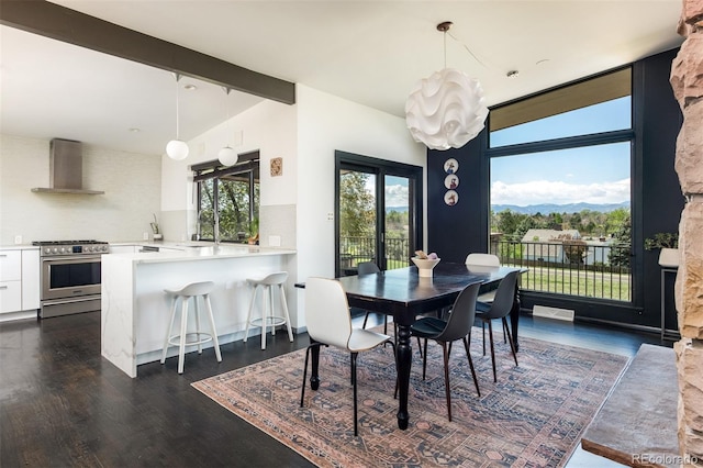 dining area with dark wood-style flooring, a mountain view, and a chandelier