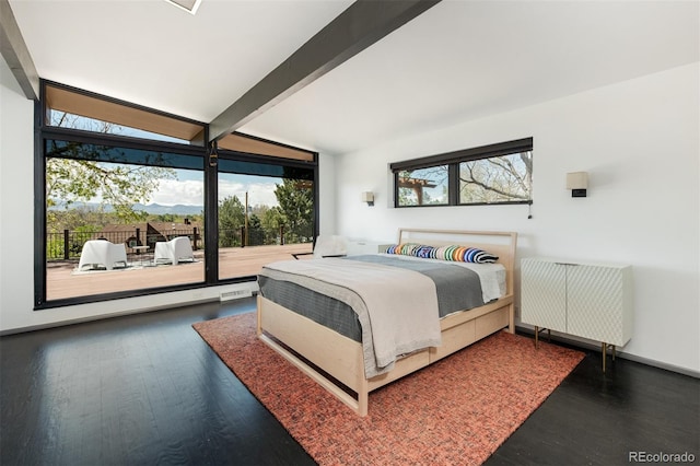 bedroom with multiple windows, wood finished floors, access to exterior, and a wall of windows