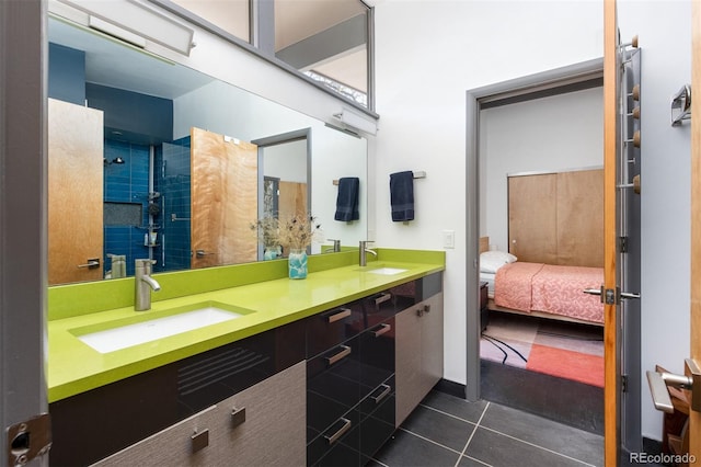 ensuite bathroom with tile patterned flooring, double vanity, and a shower